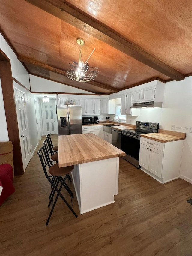 123 Rocky Rd, Lackawaxen, PA 18435 - kitchen with butcher block countertops, stainless steel appliances, under cabinet range hood, and white cabinetry