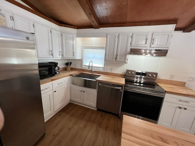 123 Rocky Rd, Lackawaxen, PA 18435 - kitchen with appliances with stainless steel finishes, a wooden ceiling with exposed beams, under cabinet range hood, wooden counters, and white cabinetry