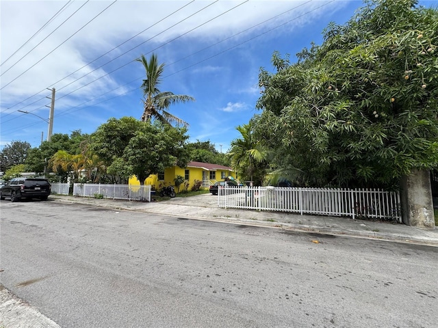 6951 NW 5th Ct, Miami, FL 33150 - view of property hidden behind natural elements featuring a fenced front yard
