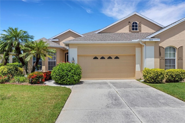 3503 92nd Ave E, Parrish, FL 34219 - ranch-style home with stucco siding, a garage, a front yard, driveway, and roof with shingles