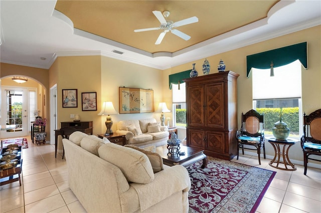 3503 92nd Ave E, Parrish, FL 34219 - living room with a tray ceiling, light tile patterned floors, arched walkways, ceiling fan, and crown molding