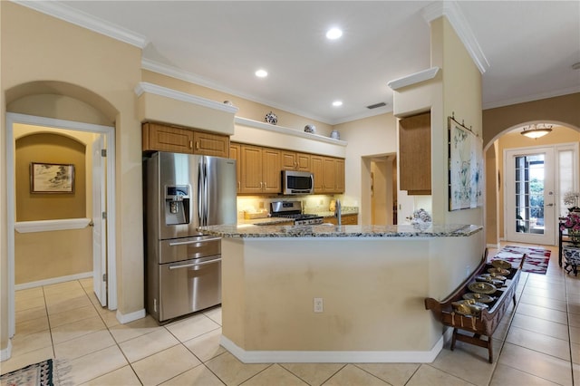 3503 92nd Ave E, Parrish, FL 34219 - kitchen featuring appliances with stainless steel finishes, arched walkways, stone counters, a peninsula, and light tile patterned floors