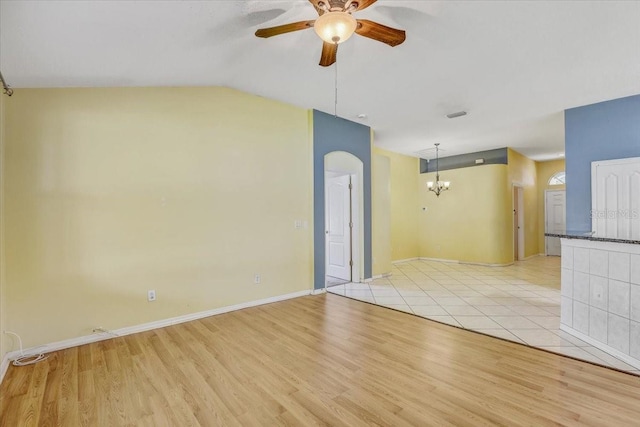 1462 Lake Shore Ranch Dr, Seffner, FL 33584 - empty room featuring a ceiling fan, arched walkways, light wood-style flooring, lofted ceiling, and a chandelier