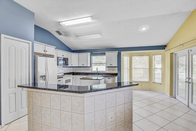 1462 Lake Shore Ranch Dr, Seffner, FL 33584 - kitchen featuring appliances with stainless steel finishes, lofted ceiling, light tile patterned floors, french doors, and white cabinetry