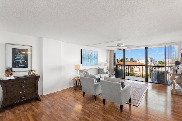 400 Island Way Unit 503, Clearwater Beach, FL 33767 - living area with a textured ceiling, expansive windows, wood finished floors, and a ceiling fan
