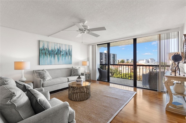 400 Island Way Unit 503, Clearwater Beach, FL 33767 - living area with a wall of windows, a ceiling fan, wood finished floors, and a textured ceiling