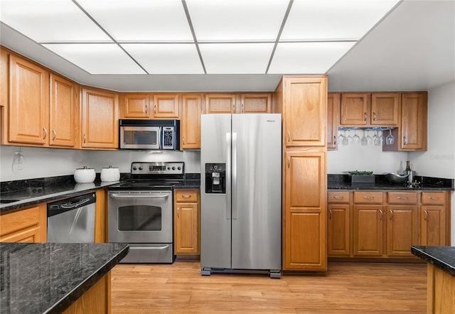 400 Island Way Unit 503, Clearwater Beach, FL 33767 - kitchen with appliances with stainless steel finishes, light wood-style floors, dark stone counters, and brown cabinets