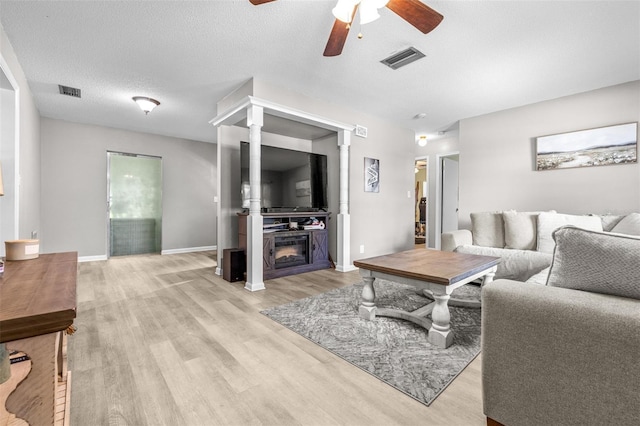6607 S Merleing Loop, Floral City, FL 34436 - living room with ceiling fan, light wood-style flooring, and a glass covered fireplace