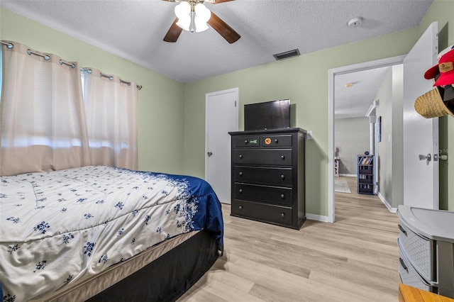 6607 S Merleing Loop, Floral City, FL 34436 - bedroom with light wood-style flooring, a textured ceiling, and a ceiling fan
