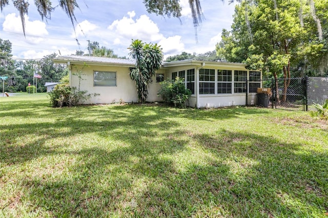 6607 S Merleing Loop, Floral City, FL 34436 - rear view of house featuring stucco siding and a sunroom