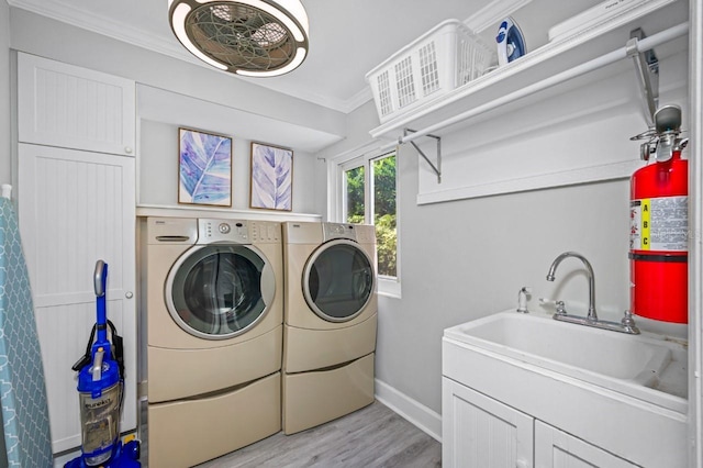 4545 Harbor Hills Dr, Largo, FL 33770 - laundry room with washing machine and dryer, ornamental molding, and light wood-style flooring