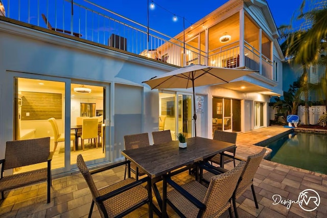 4545 Harbor Hills Dr, Largo, FL 33770 - back of house at twilight with outdoor dining area, a balcony, a patio area, and an outdoor pool
