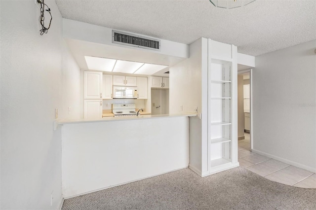 2617 Cove Cay Dr Unit 706, Clearwater, FL 33760 - kitchen with white appliances, light carpet, a textured ceiling, and light countertops