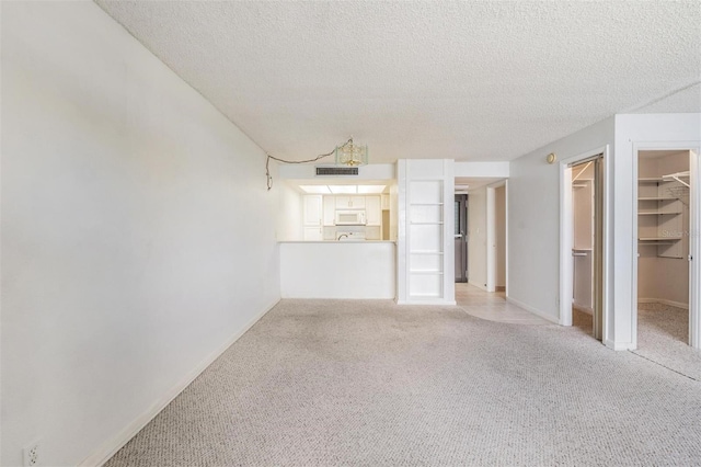 2617 Cove Cay Dr Unit 706, Clearwater, FL 33760 - unfurnished living room featuring a textured ceiling and light carpet