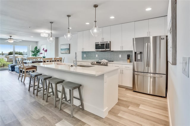 15305 1st St E Unit 305, Madeira Beach, FL 33708 - kitchen with appliances with stainless steel finishes, a breakfast bar area, recessed lighting, light wood finished floors, and decorative backsplash