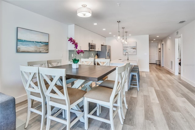 15305 1st St E Unit 305, Madeira Beach, FL 33708 - dining space with light wood-style flooring and recessed lighting