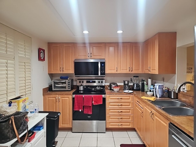 3076 Eastland Blvd Unit 210, Clearwater, FL 33761 - kitchen featuring appliances with stainless steel finishes, light tile patterned flooring, recessed lighting, and light brown cabinetry