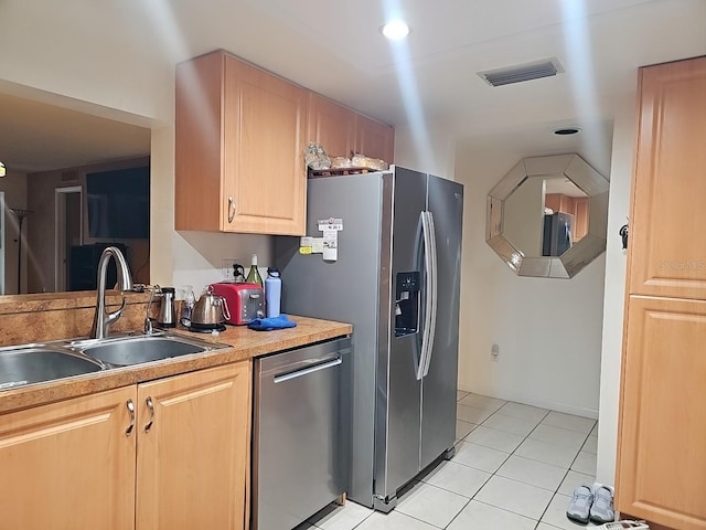 3076 Eastland Blvd Unit 210, Clearwater, FL 33761 - kitchen with appliances with stainless steel finishes, light tile patterned floors, light brown cabinetry, and light countertops