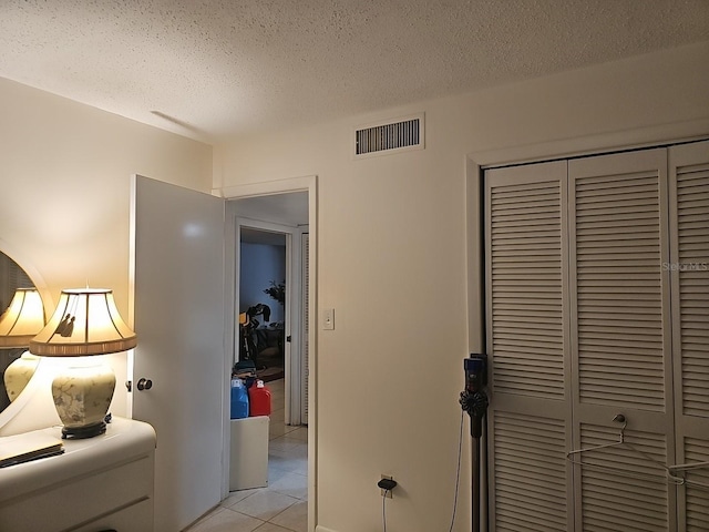 3076 Eastland Blvd Unit 210, Clearwater, FL 33761 - bedroom featuring light tile patterned flooring, a closet, and a textured ceiling