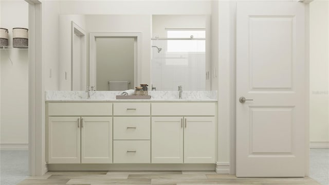 7534 E 117th Ln, Palmetto, FL 34221 - bathroom with double vanity, a shower stall, and wood finished floors