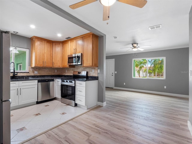 540 80th Ave, St Pete Beach, FL 33706 - kitchen featuring ceiling fan, stainless steel appliances, decorative backsplash, light wood-type flooring, and recessed lighting