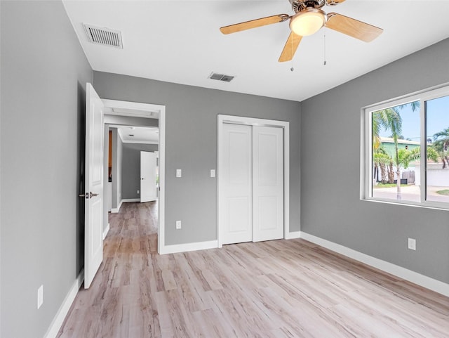 540 80th Ave, St Pete Beach, FL 33706 - unfurnished bedroom featuring light wood finished floors, a closet, and a ceiling fan