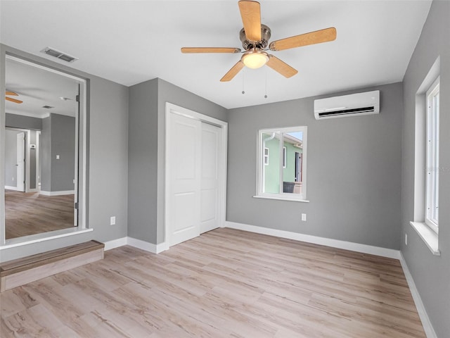 540 80th Ave, St Pete Beach, FL 33706 - unfurnished bedroom featuring light wood-style floors, a closet, a wall unit AC, and ceiling fan