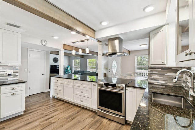 12835 74th Ave, Seminole, FL 33776 - kitchen featuring range hood, stainless steel electric range oven, decorative backsplash, white cabinets, and light wood-type flooring
