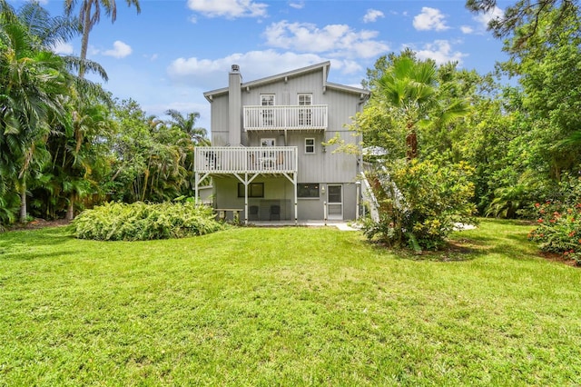 12835 74th Ave, Seminole, FL 33776 - rear view of house with a balcony, a patio area, a chimney, and a lawn