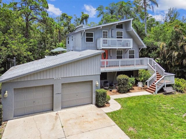 12835 74th Ave, Seminole, FL 33776 - view of front of home with a balcony, a front lawn, concrete driveway, and stairway
