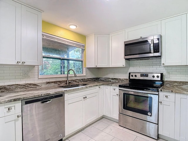 6428 Old Main St, New Port Richey, FL 34653 - kitchen featuring appliances with stainless steel finishes, stone counters, white cabinets, and tasteful backsplash