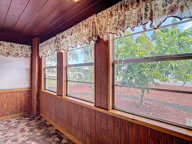6428 Old Main St, New Port Richey, FL 34653 - unfurnished sunroom featuring wood walls and baseboards