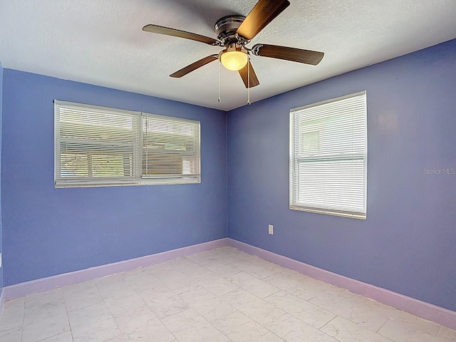 6428 Old Main St, New Port Richey, FL 34653 - empty room with a textured ceiling, a ceiling fan, and light marble finish flooring