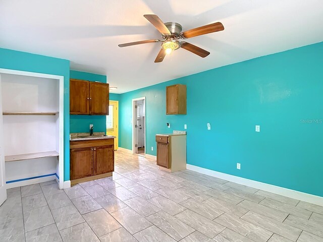6428 Old Main St, New Port Richey, FL 34653 - kitchen with brown cabinetry, a ceiling fan, and light countertops