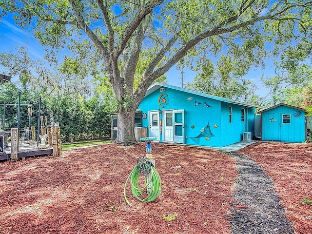 6428 Old Main St, New Port Richey, FL 34653 - view of front facade featuring stucco siding, a storage shed, and a wooden deck
