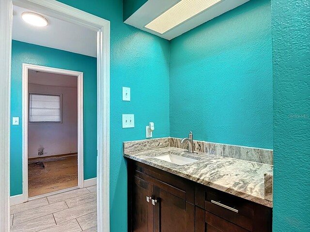 6428 Old Main St, New Port Richey, FL 34653 - bathroom with vanity, a textured wall, and wood finish floors