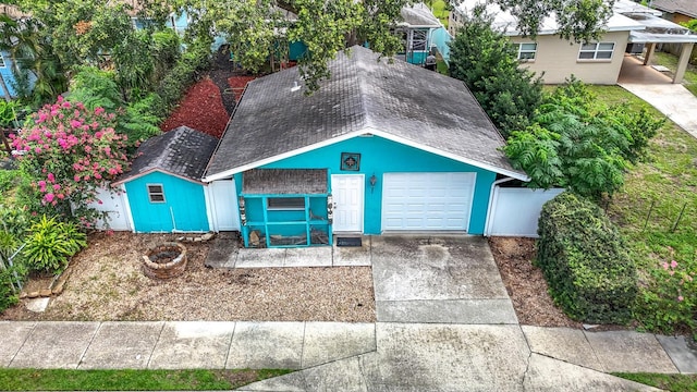 6428 Old Main St, New Port Richey, FL 34653 - ranch-style home with roof with shingles, a garage, concrete driveway, and an outbuilding