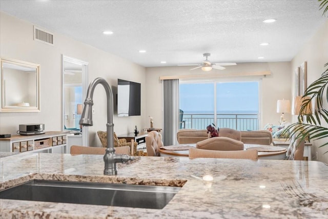 13000 Gulf Blvd Unit 309, Madeira Beach, FL 33708 - kitchen featuring a textured ceiling, light stone counters, a ceiling fan, and recessed lighting