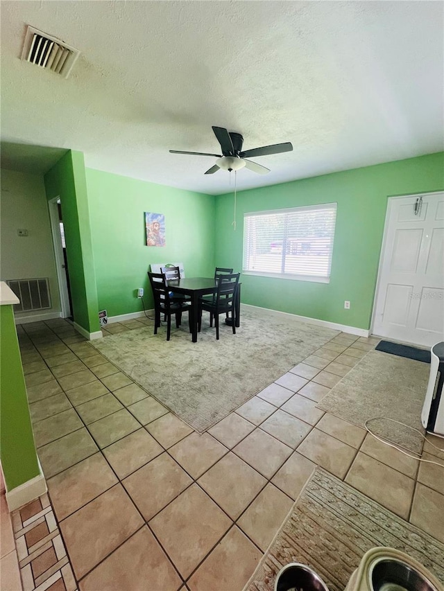 6316 Alaska Ave, New Port Richey, FL 34653 - dining room with light tile patterned floors, ceiling fan, a textured ceiling, and light colored carpet