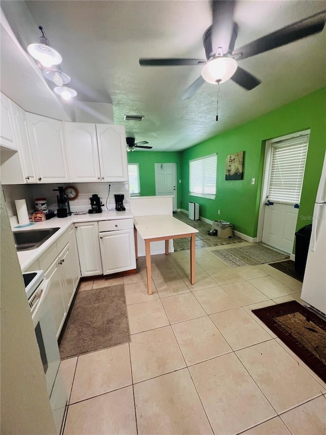 6316 Alaska Ave, New Port Richey, FL 34653 - kitchen featuring white cabinetry, a ceiling fan, light countertops, light tile patterned flooring, and white appliances