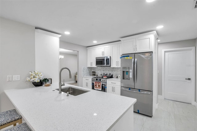2585 Ridge Ln, Palm Harbor, FL 34684 - kitchen featuring appliances with stainless steel finishes, a peninsula, white cabinetry, recessed lighting, and light marble finish flooring