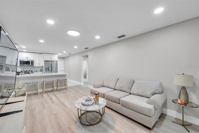 2585 Ridge Ln, Palm Harbor, FL 34684 - living room featuring light wood-style floors and recessed lighting