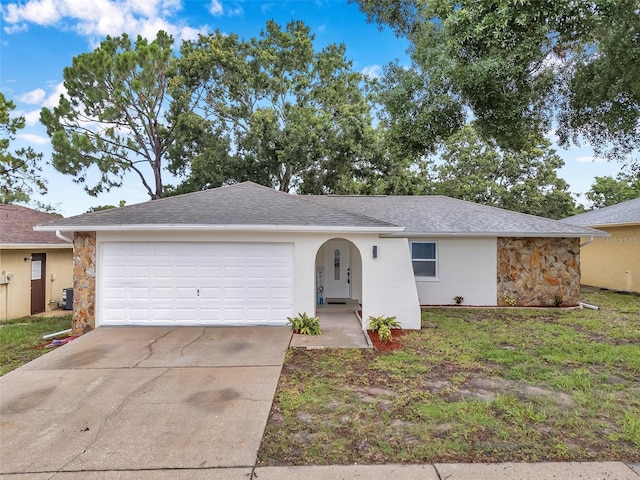 2585 Ridge Ln, Palm Harbor, FL 34684 - ranch-style home featuring stone siding, concrete driveway, an attached garage, and stucco siding