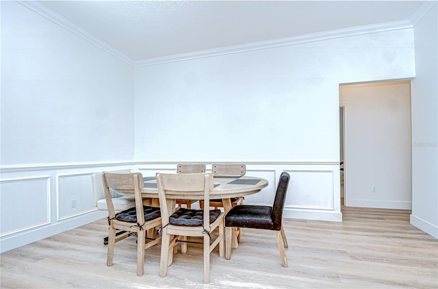 3012 Colonial Ridge Dr, Brandon, FL 33511 - dining room featuring light wood-type flooring, crown molding, a decorative wall, and a wainscoted wall
