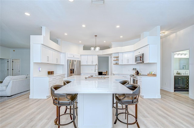 3012 Colonial Ridge Dr, Brandon, FL 33511 - kitchen with stainless steel appliances, a breakfast bar, light wood finished floors, a large island with sink, and recessed lighting