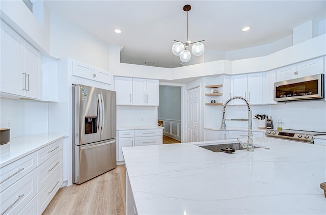 3012 Colonial Ridge Dr, Brandon, FL 33511 - kitchen with stainless steel appliances, open shelves, white cabinets, light wood-style floors, and light stone counters