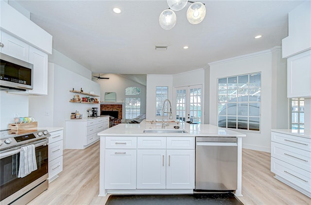 3012 Colonial Ridge Dr, Brandon, FL 33511 - kitchen with appliances with stainless steel finishes, white cabinets, light countertops, ornamental molding, and a center island with sink