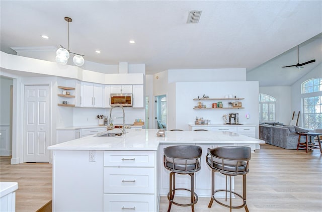 3012 Colonial Ridge Dr, Brandon, FL 33511 - kitchen featuring open shelves, stainless steel microwave, light wood-type flooring, white cabinetry, and recessed lighting