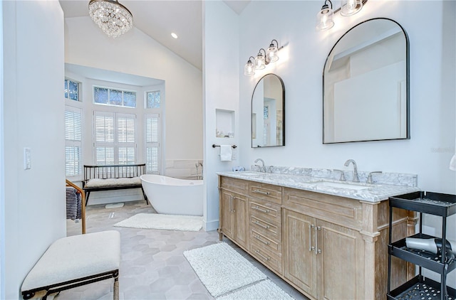 3012 Colonial Ridge Dr, Brandon, FL 33511 - full bathroom featuring double vanity, a freestanding bath, high vaulted ceiling, and a chandelier