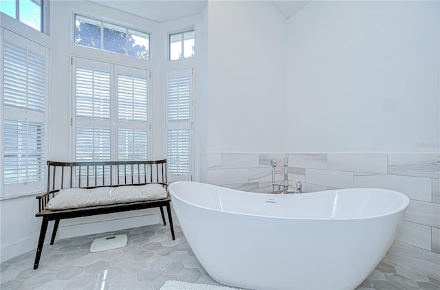3012 Colonial Ridge Dr, Brandon, FL 33511 - full bathroom with a freestanding bath, healthy amount of natural light, tile patterned flooring, tile walls, and wainscoting